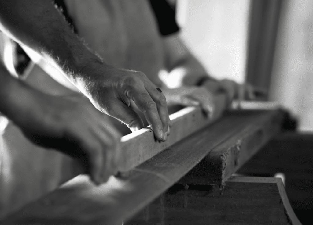 Five generations of woodworking mastery: Artisan hands shaping a custom solid wood casket at Randolph's Custom Caskets in North Carolina